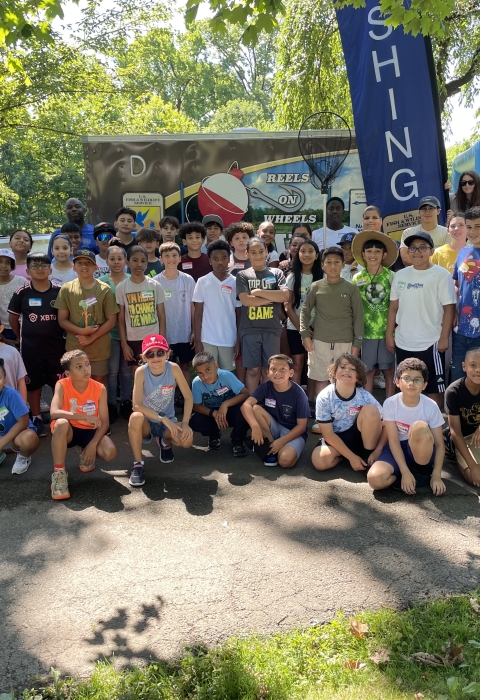 Participants pose for a group photo at the 2024 Cops and Bobbers Fishing Event as part of the Elizabeth Urban Wildlife Refuge Partnership at Warinanco Park in Elizabeth, New Jersey