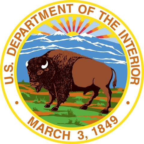 logo of the U.S. Department of the Interior. An illustration of a bison on an open field, mountains behind and the rays of the sun emerging. Encircling is the department name and the date March 3, 1849, when the agency was founded.