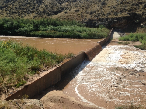 A body of water waterfalling over a barrier