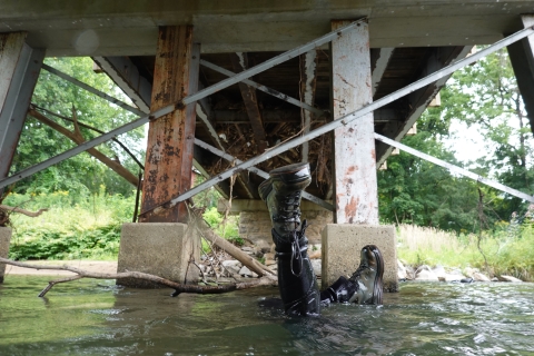 A pair of feet stick up into the air as a snorkeler dives for the river bottom