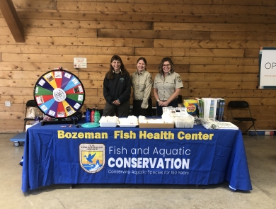 Biologists attend a table with education materials