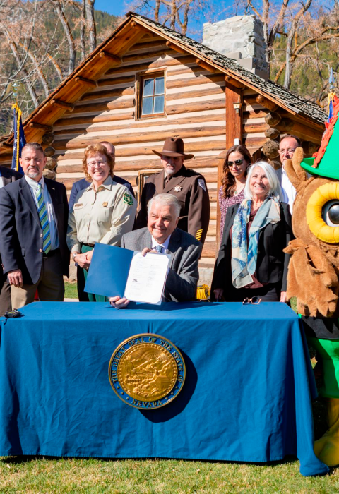 A group of people standing behind Nevada governor Steve Sisolak during a document signing event