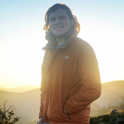 man with mountains and sun in the background
