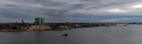 an aerial view of a city and a river at dusk with cloudy skies