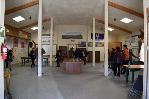A school group in the education building on Rio Mora National Wildlife Refuge looking at educational materials on tables and walls.