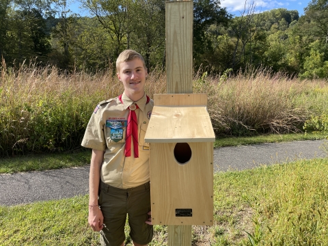 Eagle Scout Hunter Zeman of Troop 41 out of Johnsonville, Pennsylvania poses for a photo with one of his owl nest boxes at the Cherry Valley National Wildlife Refuge