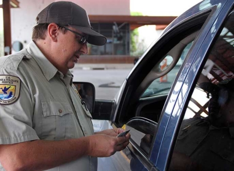 Wildlife Inspector Jeff Moore stands in next to an open car window to speak to the driver.