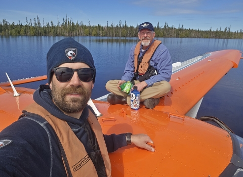 two pilot biologists sitting on top of a seaplane