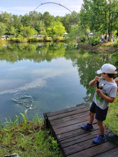Fish bit the lure and a young angler is battling with a bent fishing rod