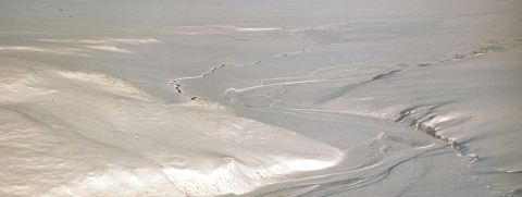 Wintery scene from above showing hills and a river covered in snow