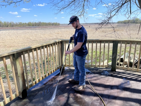 Volunteer doing maintenance on a observation deck.