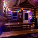 Colored lights decorate the cozy interior of the Dolly Varden log public use cabin at Kenai Refuge on Dolly Varden Lake.