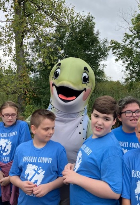 Group of kids smiling with fish mascot
