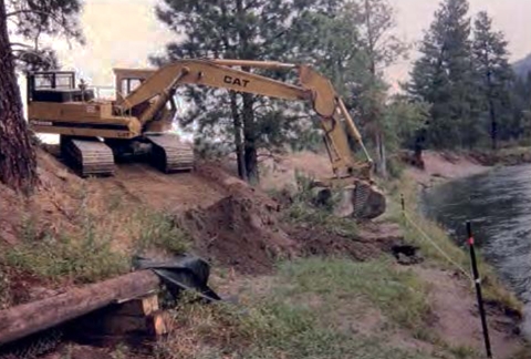 Heavy equipment on a hillside digs the beginning of the new trail.