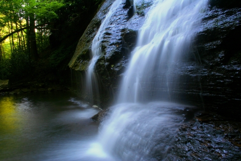 Water cascading over rock into pool in the Upper Tennessee River Basin with trees in background