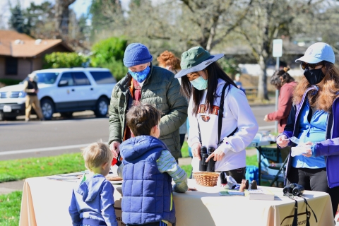 Three solunteer teaching two young boys about birds at the Winter Wildlife Field Day Festival