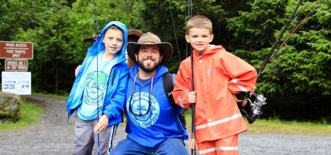 Volunteer camp instructor Matt Thomas with two young anglers at Kodiak National Wildlife Refuge in Alaska.