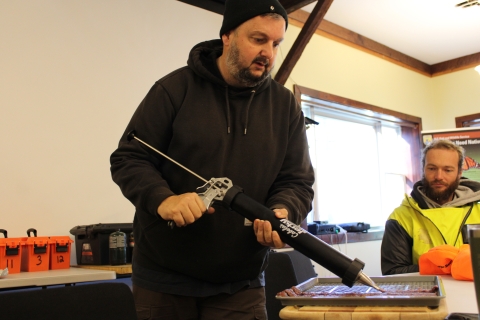 Mentor Mike (L) shows participants how to prepare deer jerky as Mentee Sam (R) watches as part of the Field to Fork mentored rifle deer hunt at Cherry Valley National Wildlife Refuge in December 2024.