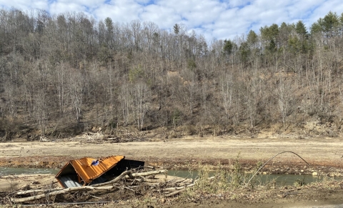 A crumpled shipping container in the Cane River.