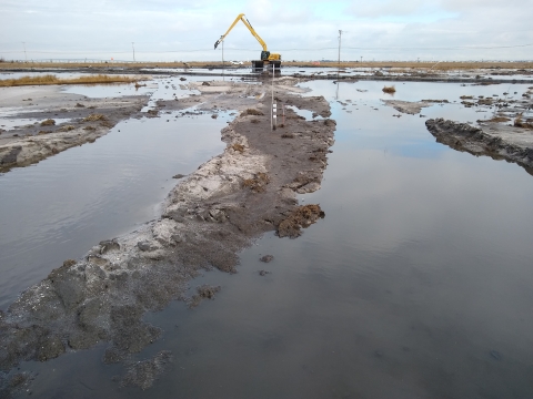 Excavator moving sediment onto the refuge marsh