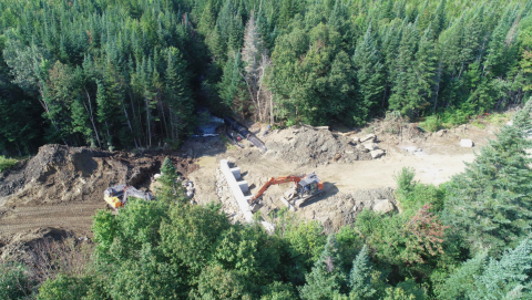 Aerial view of ongoing construction on a stream crossing/culvert replacement with surrounding forest