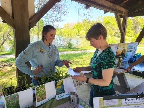 Biologist shows plants that are good for pollinators to a military resource office