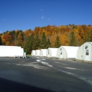 A row of white buildings amidst a mountainous forest setting