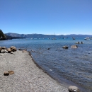 Shoreline of Lake Tahoe with boats in the distance.