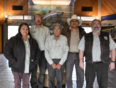 Five people stand in a row wearing USFWS logo uniform clothing.