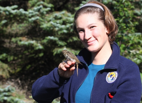 smiling woman holds a small bird