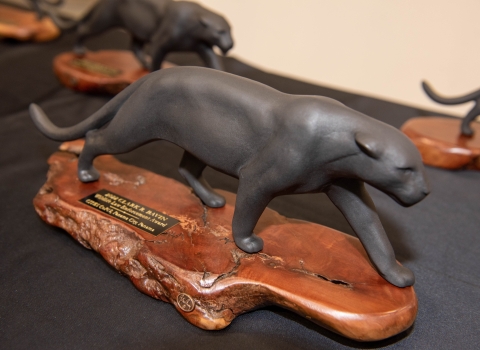 A statuette of a jaguar on a wooden pase