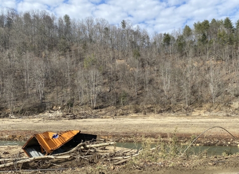 A crumpled shipping container in the Cane River.